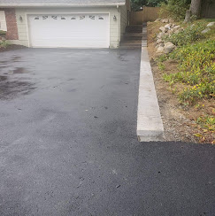 Freshly paved asphalt driveway with granite curb