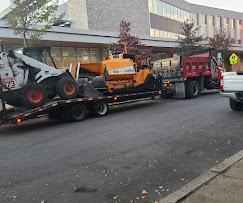 Paver and skid steer on a trailer